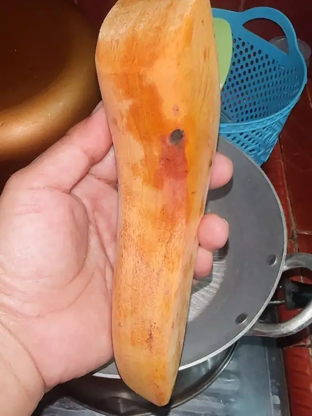 Ulekan kayu dipegang tangan, berwarna oranye bekas bumbu